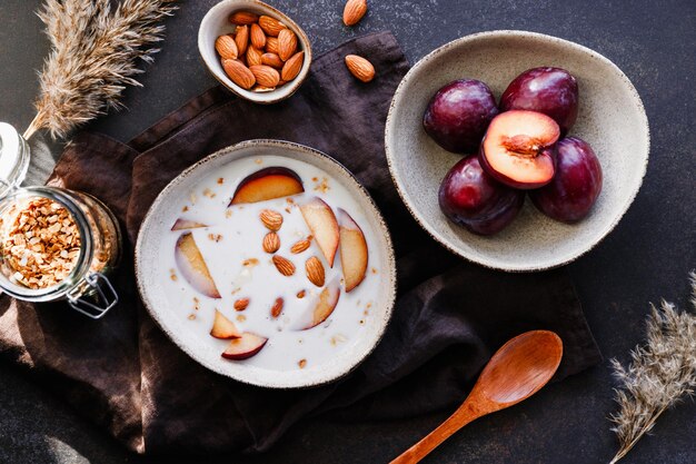 Vue grand angle de la bouillie du matin avec des amandes et des tranches de prune Petit-déjeuner énergétique sain