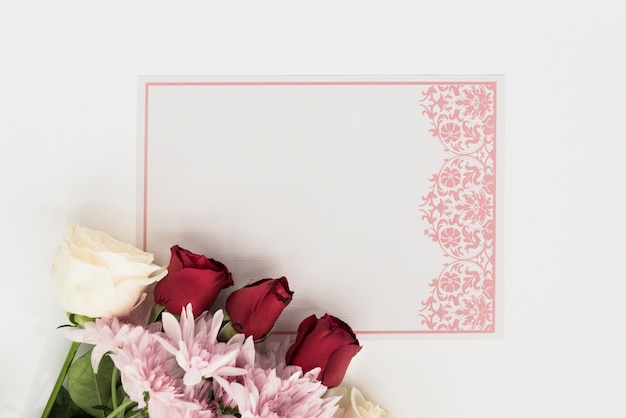 Vue grand angle de carte vierge avec de belles roses sur fond blanc