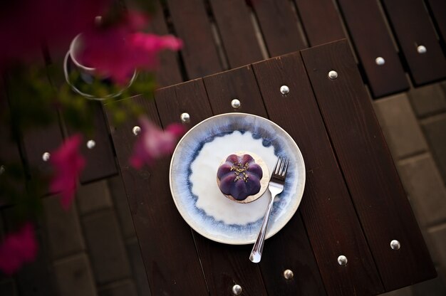 Vue grand angle d'un délicieux dessert végétalien cru fait à la main servi sur une assiette sur une table en bois. Fond de nourriture