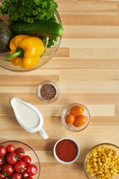 Vue grand angle d'épices de légumes frais et d'autres ingrédients sur la table en bois pour la cuisson