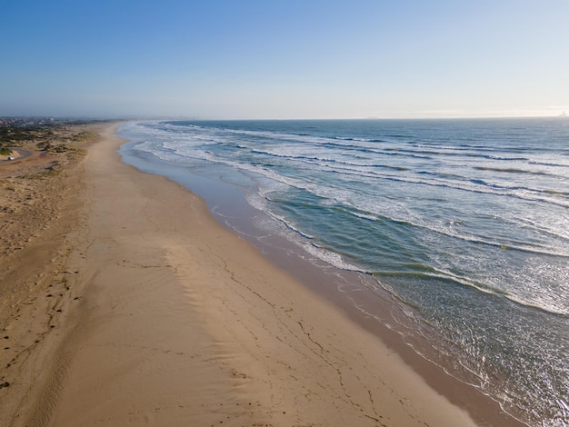 Vue grand angle des vagues roulant sur le littoral