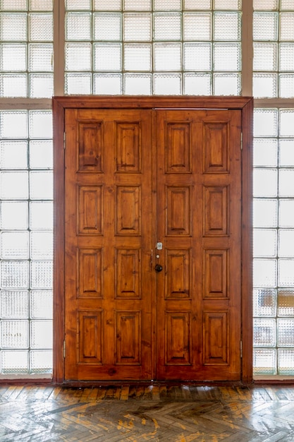 Vue d'une grande porte en bois dans un mur de blocs de verre