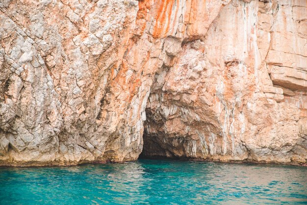 Vue de la grotte dans la falaise rocheuse avec de l'eau azur