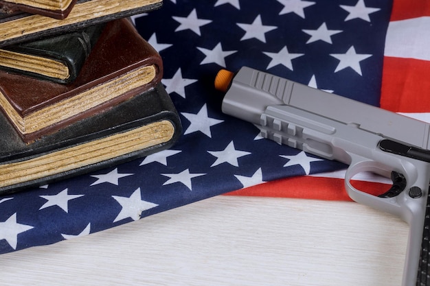 Photo vue à haut angle de l'arme de poing par des livres et un drapeau sur la table