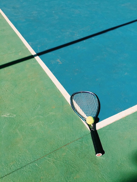 Vue à haut angle de la balle de tennis et de la raquette sur le terrain
