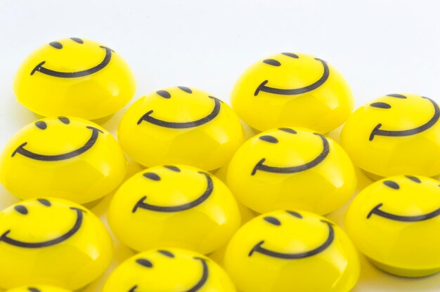 Photo vue à haut angle des balles smiley jaunes sur fond blanc