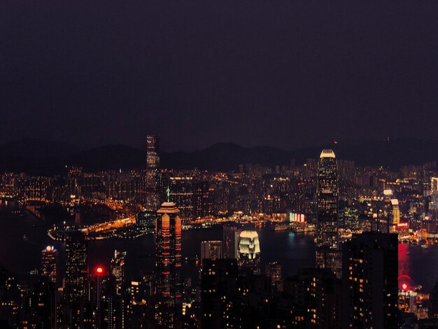 Vue en haut angle des bâtiments éclairés contre le ciel la nuit