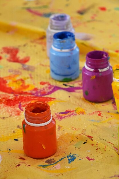 Vue à haut angle de bouteilles de peinture colorées sur du papier en désordre