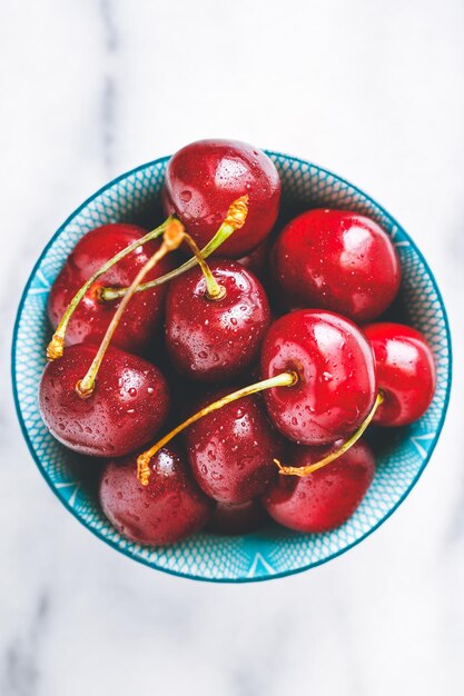 Photo vue à haut angle des cerises mouillées dans un bol sur la table