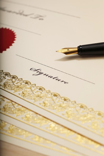 Photo vue à haut angle des certificats en blanc et du stylo plume sur table en bois