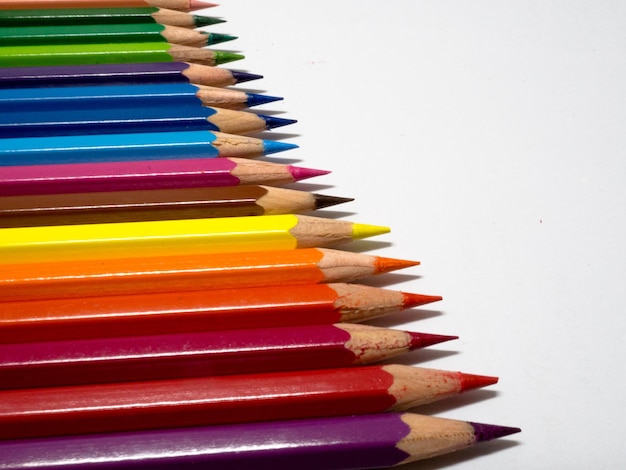 Vue à haut angle des crayons de couleur en rangée sur fond blanc