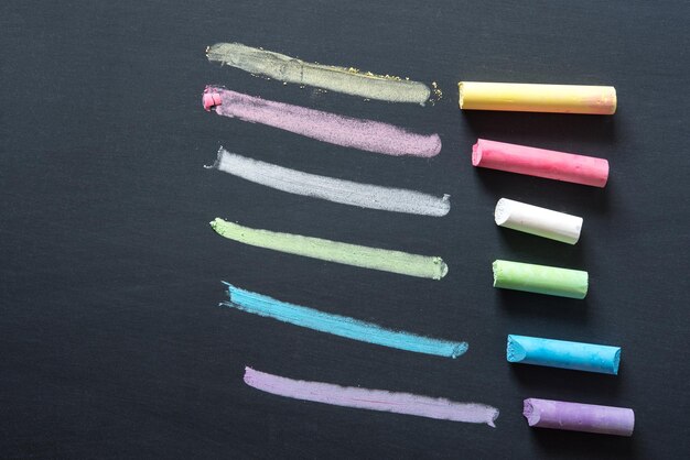 Photo vue à haut angle des crayons multicolores sur la table contre un fond noir