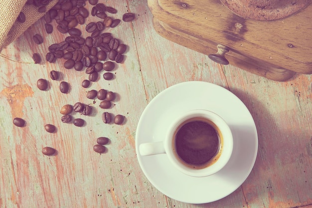 Vue à haut angle du café dans la tasse et du broyeur sur la table