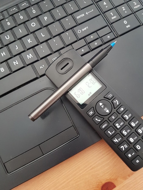 Vue à haut angle du clavier de l'ordinateur portable avec téléphone et stylo