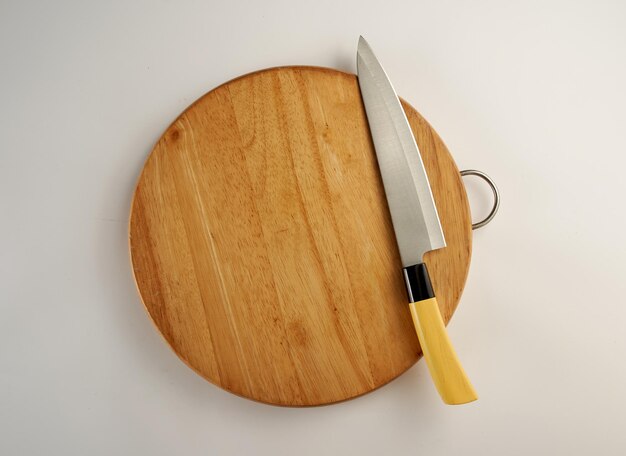 Vue à haut angle du couteau de cuisine sur la planche à découper sur fond blanc