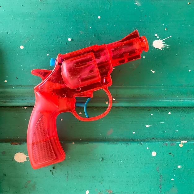 Photo vue à haut angle du pistolet jouet rouge sur la table