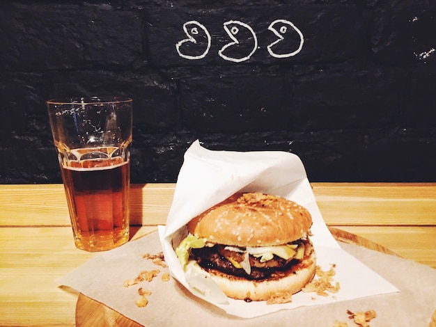Vue à haut angle du verre de hamburger et de bière sur une table en bois