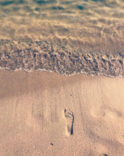 Photo vue en haut angle des empreintes de pieds sur le sable de la plage