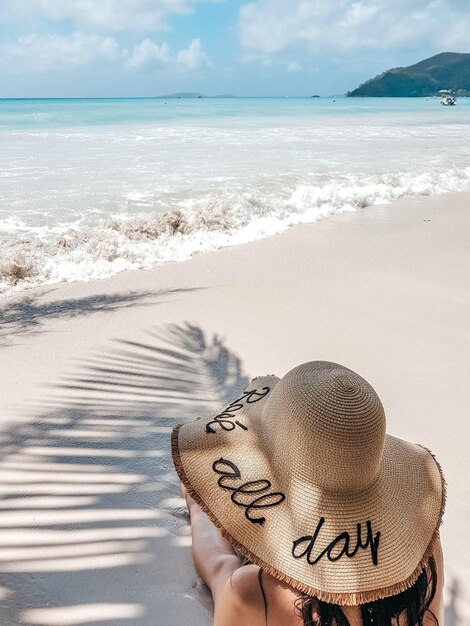 Photo vue en haut angle d'une femme avec un chapeau d'été sur une plage de sable tropical vacances loisirs
