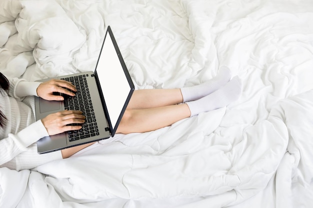 Vue à haut angle d'une femme utilisant un ordinateur portable sur le lit