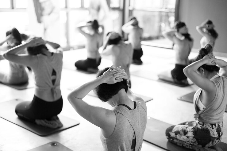 Photo vue à haut angle de femmes faisant de l'exercice alors qu'elles s'agenouillent sur des tapis d'exercice dans un club de santé