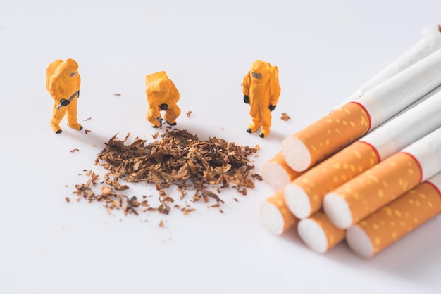 Vue à haut angle de figurines avec des cigarettes sur fond blanc