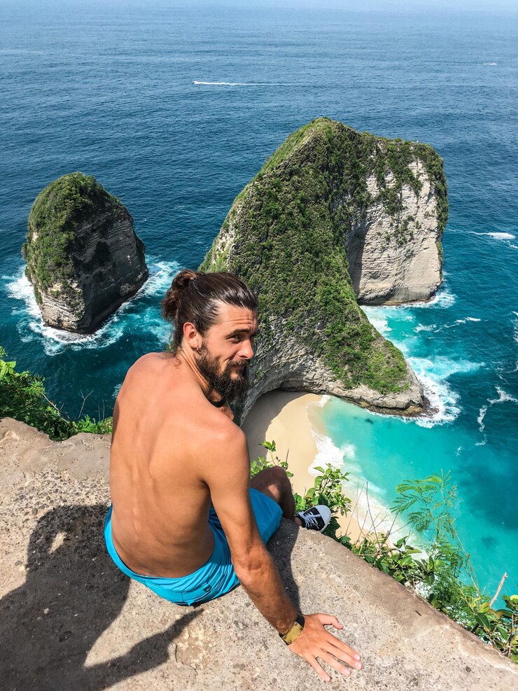Photo vue en haut angle d'un jeune homme regardant la mer