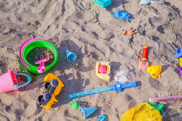 Vue à haut angle des jouets multicolores sur le sable