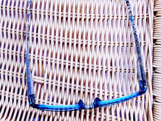 Photo vue à haut angle des lunettes bleues sur un siège en osier
