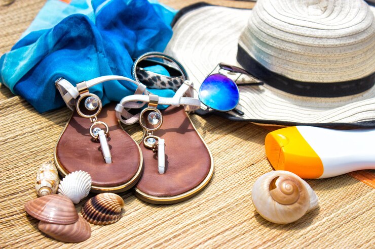 Photo vue à haut angle des lunettes de soleil avec chapeau et accessoires personnels sur le tapis