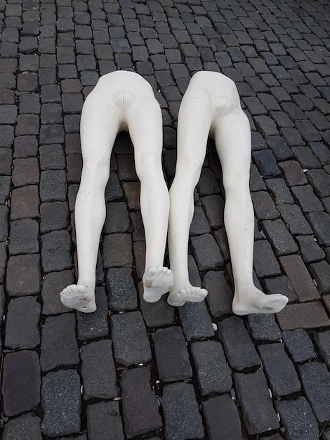 Vue à haut angle des mannequins cassés sur une rue pavée