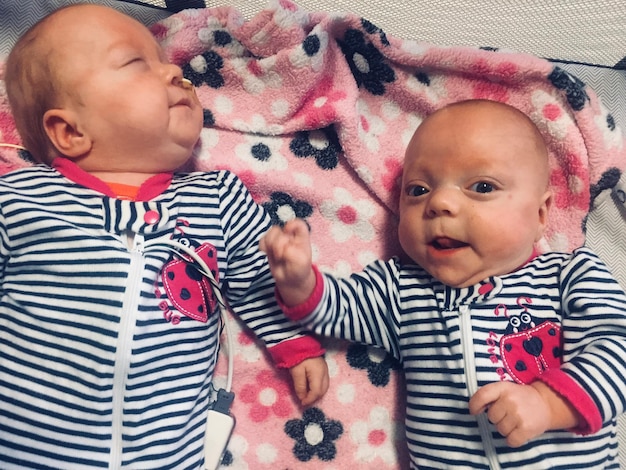 Photo vue à haut angle de mignons bébés allongés sur le lit à la maison