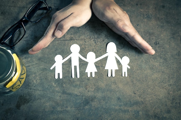 Photo vue à haut angle d'une personne avec les mains de la famille de papier sur la table