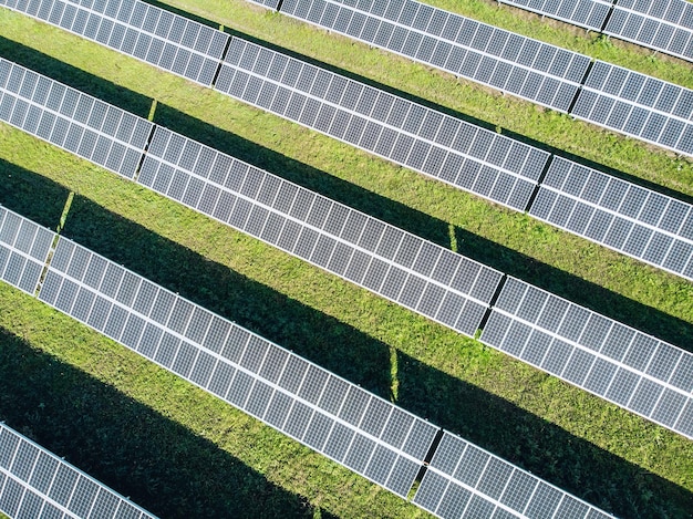 Vue de haut en bas du drone sur d'immenses champs de jardin et sur les panneaux solaires supérieurs en ligne. Notion d'énergie renouvelable