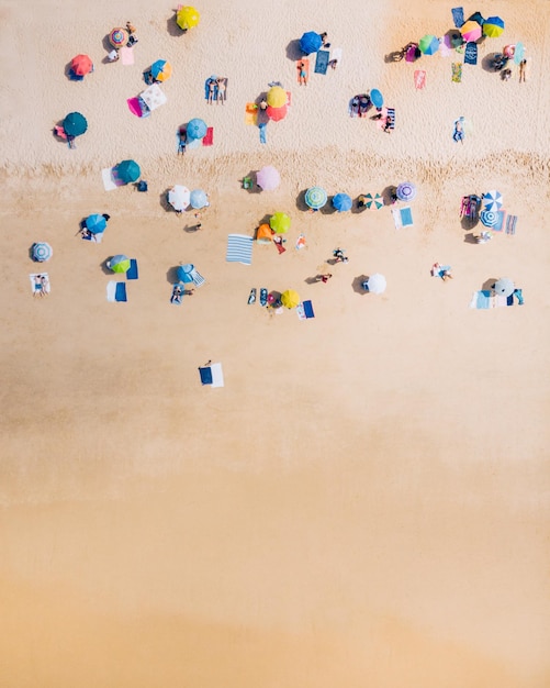 Photo vue de haut en bas d'une plage avec des parapluies de plage