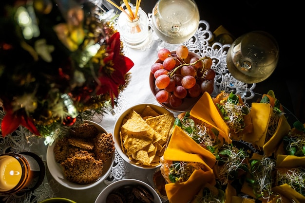 Photo vue de haut des collations buffet telles que des biscuits de raisins, des sandwichs de nachos et des noix sur une table