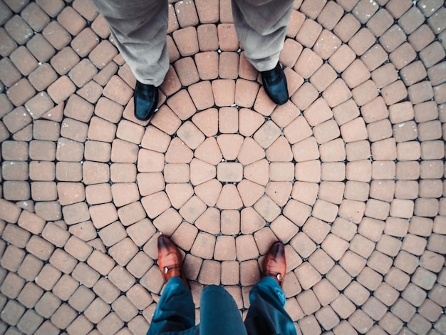 Photo vue d'en haut de deux hommes debout sur un trottoir circulaire disposé