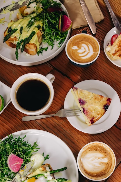 Vue d'en haut des différents plats et boissons pour le petit déjeuner et le brunch sur la table en bois