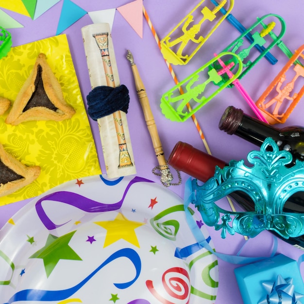 Photo vue de haut des objets colorés de la fête de pourim sur un fond violet