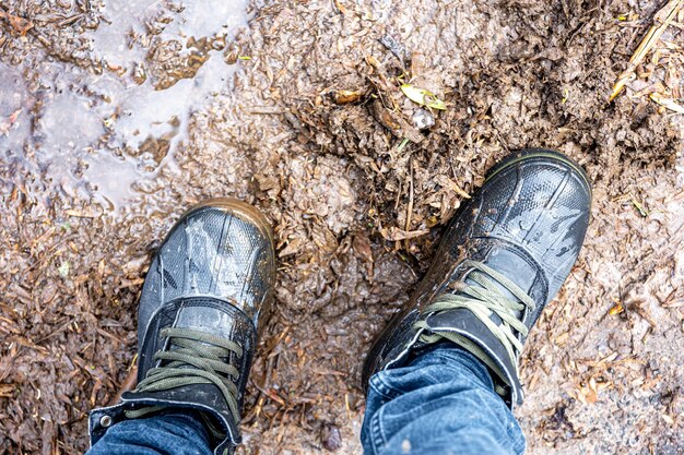 Vue d'en haut sur une paire de chaussures de trekking dans la boue