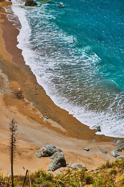 Vue d'en haut de la plage avec de belles vagues bleues de l'océan qui se brisent