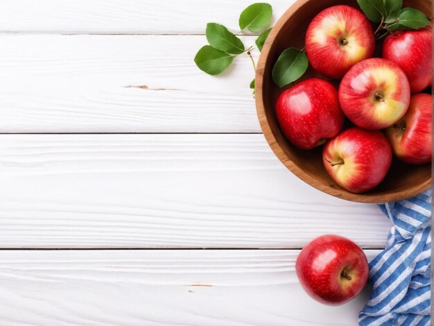 Vue de haut des pommes rouges fraîches Vue rapprochée des pommes rouge fraîches sur un bol en bois sur un fond en bois blanc