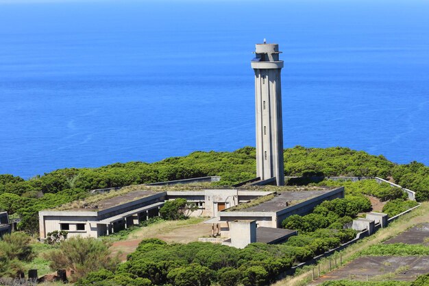 Photo vue haute angle du phare par la mer contre le ciel