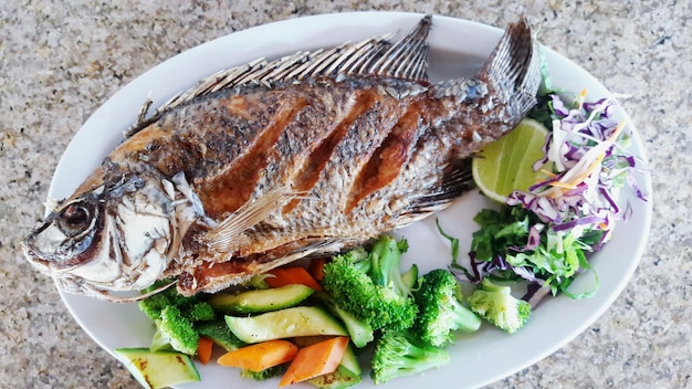 Vue haute angle du poisson et des légumes servis sur la table