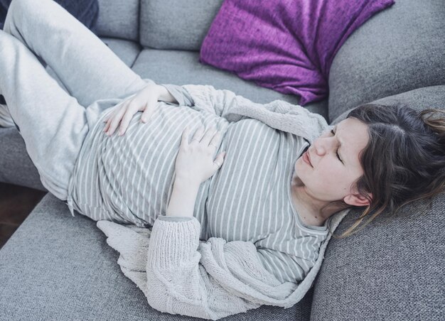 Photo vue haute angle d'une femme qui dort sur le lit à la maison