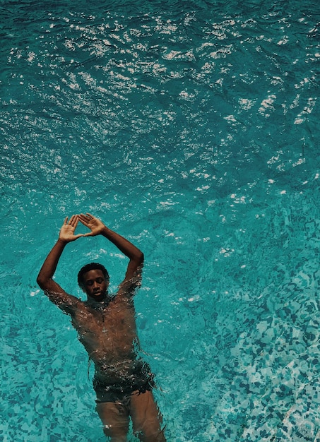 Vue haute angle d'un homme sans chemise nageant dans la piscine