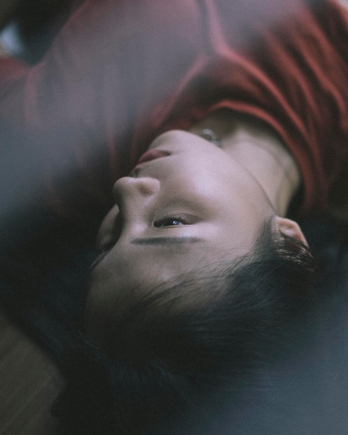 Vue haute angle d'une jeune femme allongée sur le lit à la maison