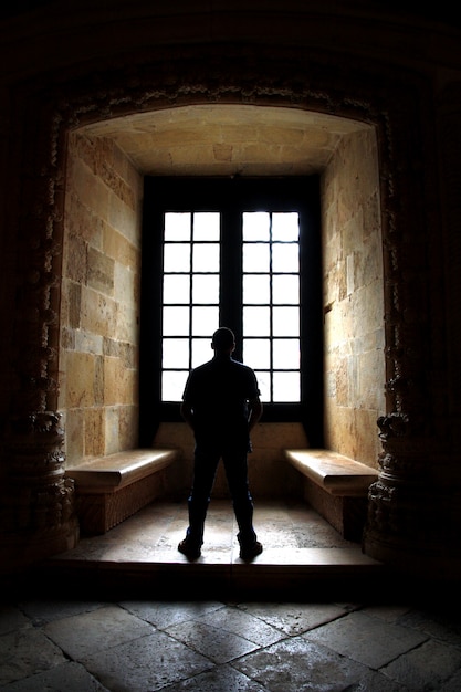 Vue d&#39;un homme seul face à une fenêtre à l&#39;intérieur d&#39;un couvent.