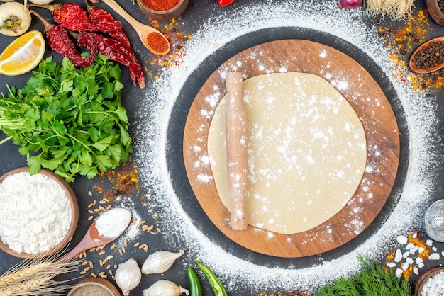 Vue horizontale du rouleau à pâtisserie sur la pâte circulaire