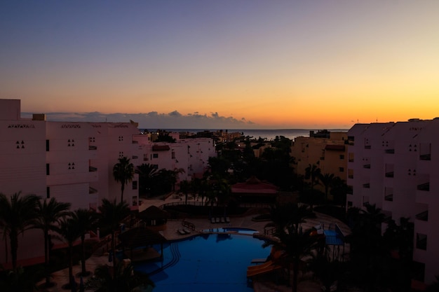 Vue de l'hôtel luxueux avec piscine et mer Rouge au lever du soleil